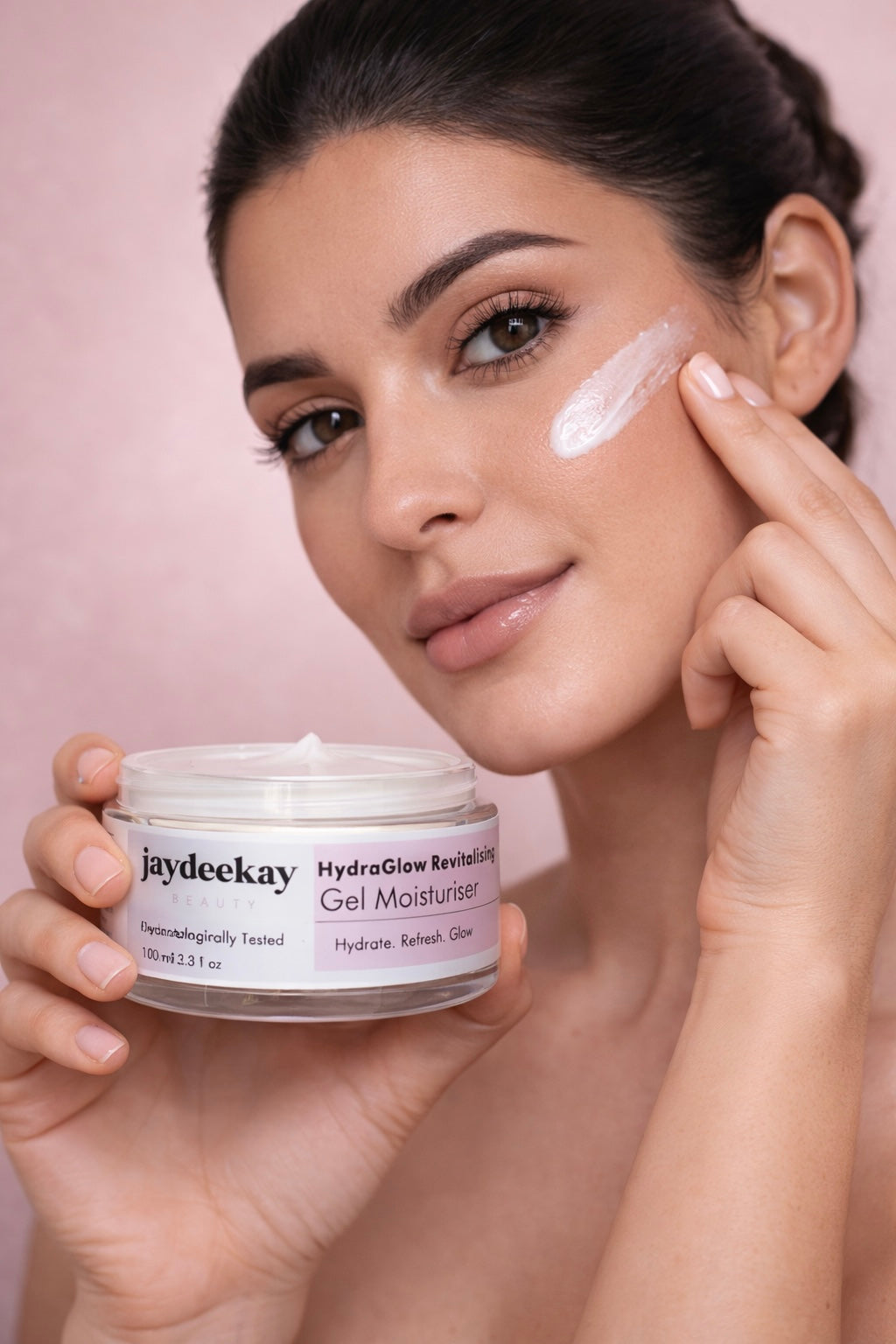 Woman applying gel moisturizer to her face with a jar of Jaydeekay product.